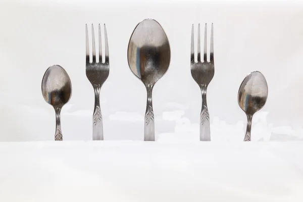 Colheres e garfos, pequenas colheres em um fundo branco — Fotografia de Stock