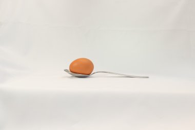 Kaşık beyaz bir arka plan üzerinde yumurta