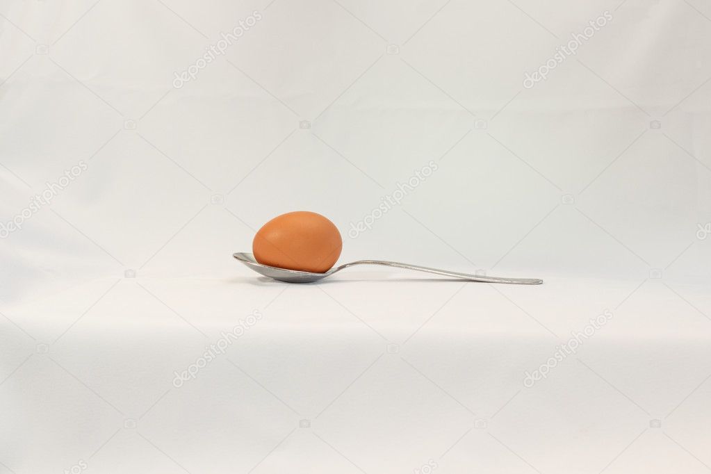 Egg in spoon on a white background