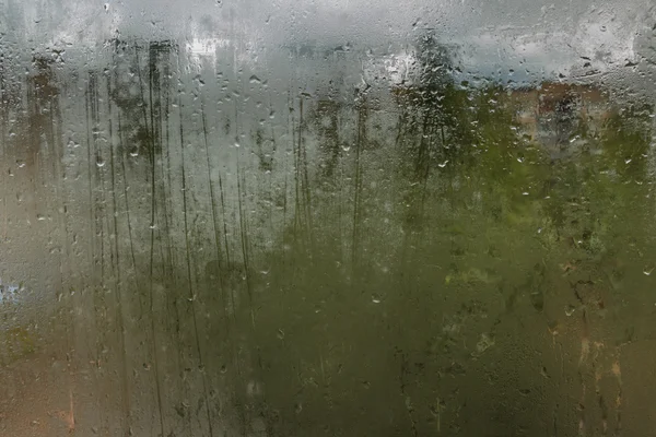 Gotas de lluvia en un vaso sudoroso. Tristeza tristeza tristeza otoño . — Foto de Stock