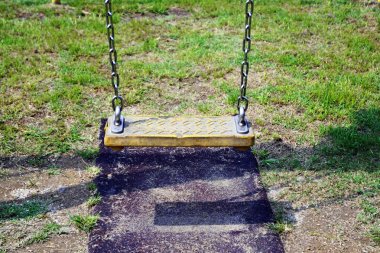 Çocuklar oyun alanında boş zincir sallanır