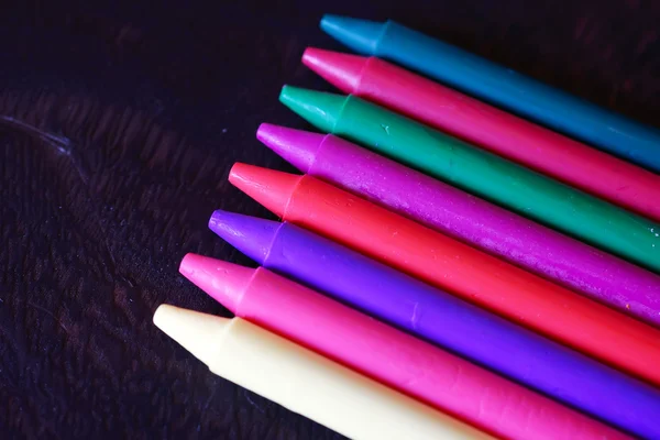 Coloridos crayones pastel de aceite sobre una mesa negra de madera —  Fotos de Stock