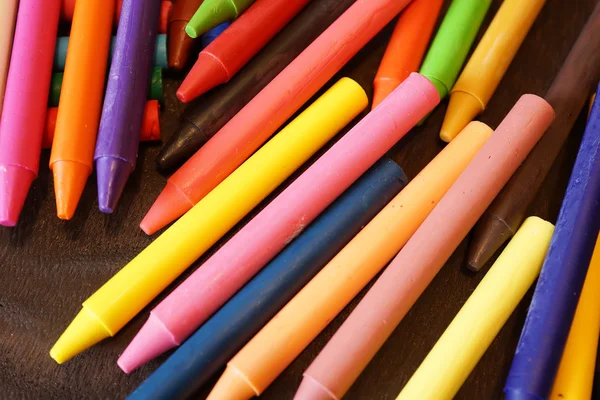 Coloridos crayones pastel de aceite sobre una mesa negra de madera —  Fotos de Stock