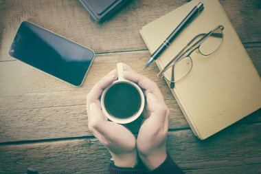 Bir fincan kahve tutan kadın elleri