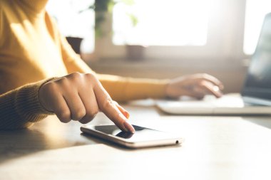 Ofis masasında klavyesi olan kadın cep telefonu.