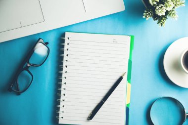 Üzerinde klavye ve kahve olan not defteri.