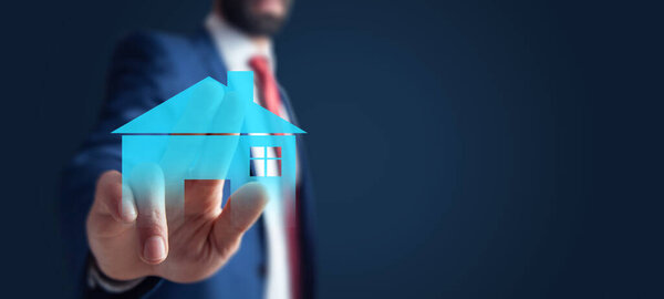 человек ручной модели дома на экране