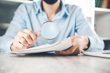 Masasında büyüteç olan el dokümanı
