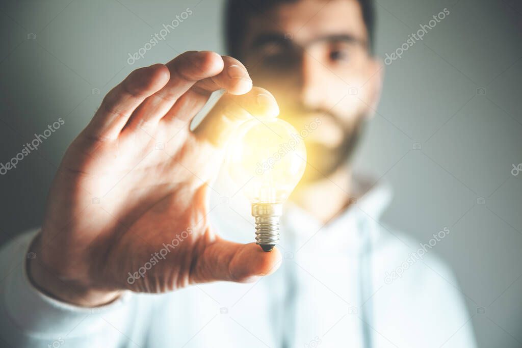 man hand holding light bulb