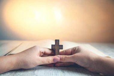 Kadın eli ahşap haç ve kitap