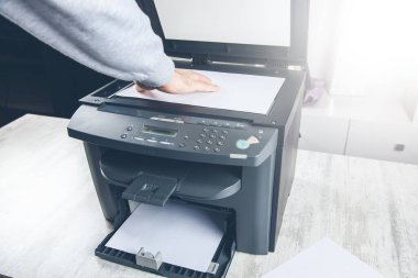 Ofisinde fotokopi makinesi olan işçi.