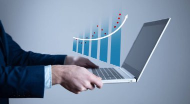 İş adamı büyüyen bilgisayarla çalışıyor