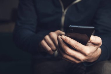 Akıllı telefonu tutan genç adam.