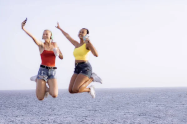 Two Happy Joyful Young Women Jumping Laughing Together Sea Background — Foto de Stock