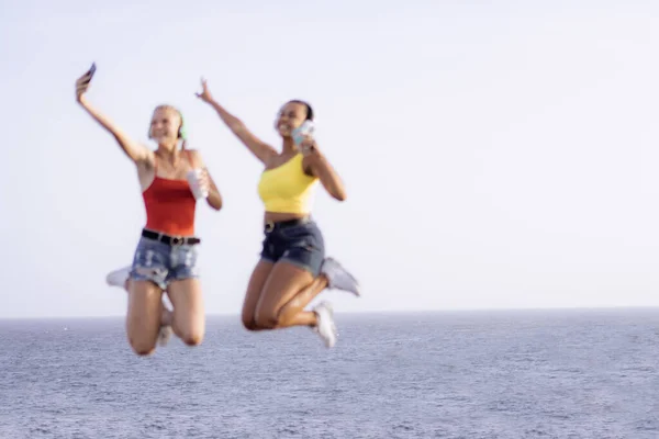 Duas Jovens Alegres Felizes Pulando Rindo Juntas Sobre Fundo Mar — Fotografia de Stock