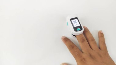 Elimizde bulunan dijital nabız oksimetresi koronavirüsün oksijen doygunluğunu ya da beyaz arka planda covid 19 hastayı kontrol etmek için kullanılır.