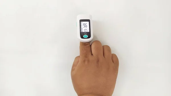 Elimizde bulunan dijital nabız oksimetresi koronavirüsün oksijen doygunluğunu ya da beyaz arka planda covid 19 hastayı kontrol etmek için kullanılır.