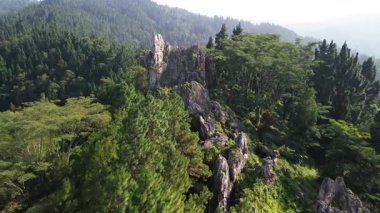 Karang Gemantung Taş Parkı 'nın hava aracı görüntüsü, Banjarnegara, Merkez Java, Endonezya. Tepelerin ortasındaki mercan kayaları, yemyeşil orman ve ağaçlarla çevrili..