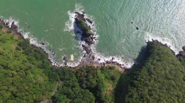 Karang Agung Sahili, Kebumen, Central Java, Endonezya 'nın insansız hava aracı görüntüsü. Kıyı şeridi yoğun ağaçlarla ve okyanustan gelen dalgalarla çevrili mercan kayalarıyla çevrilidir..