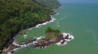 Karang Agung Sahili, Kebumen, Central Java, Endonezya 'nın insansız hava aracı görüntüsü. Kıyı şeridi yoğun ağaçlarla ve okyanustan gelen dalgalarla çevrili mercan kayalarıyla çevrilidir..