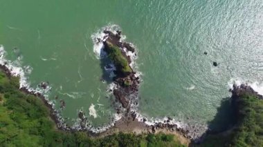 Karang Agung Sahili, Kebumen, Central Java, Endonezya 'nın insansız hava aracı görüntüsü. Kıyı şeridi yoğun ağaçlarla ve okyanustan gelen dalgalarla çevrili mercan kayalarıyla çevrilidir..