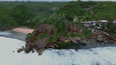 Ngobaran Sahili, Gunung Kidul, Yogyakarta, Hint Okyanusu manzaralı mercan kayalıkları ve dalgaları olan turistik bir plaj, mercan kayalıklarının tepesinde Segara Wukir tapınağı var.