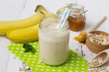 Muz smoothies beyaz bir arka plan üzerinde cam kavanozda