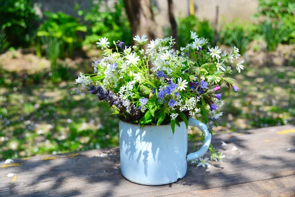 Bouquet of spring flowers in an iron cup — Stock Photo, Image