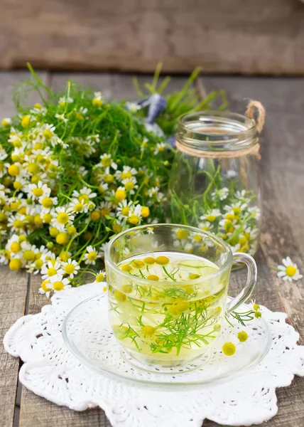 Kamille thee in een beker glas op een houten achtergrond — Stockfoto