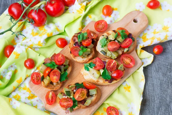 Bruschetta com abobrinha, bacon, cebola verde e tomate cereja — Fotografia de Stock