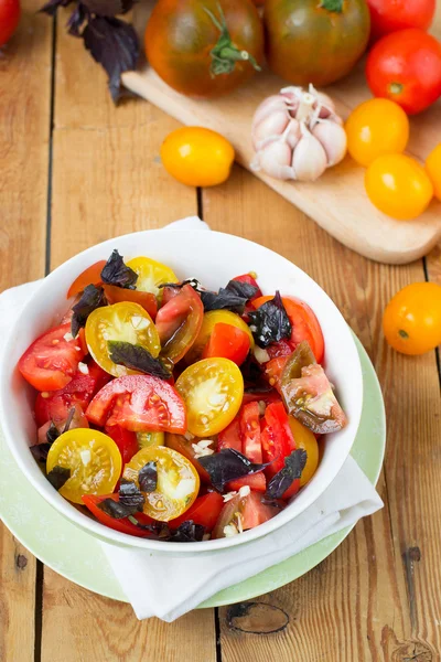 Salad of colorful tomatoes on a wooden background — Stock Photo, Image