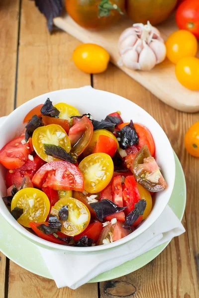 Salad of colorful tomatoes on a wooden background — Stock Photo, Image