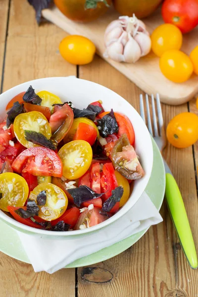 Salad of colorful tomatoes on a wooden background — Stock Photo, Image