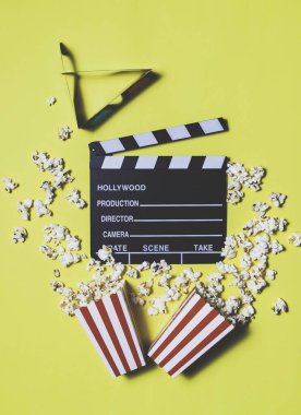 Sinema, eğlence, görsel ve işitsel konulardaki kavramsal sarı arka planda film ve patlamış mısır.