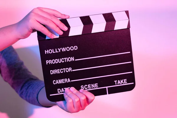 Las Manos Sostienen Una Película Clapperboard Bajo Luces Rojas Azules Imagen De Stock