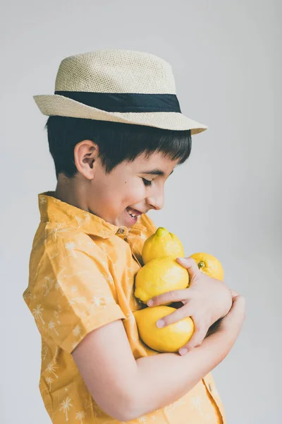 Lächelnder Junge Mit Strohhut Hält Ein Paar Zitronen Arm Konzept — Stockfoto