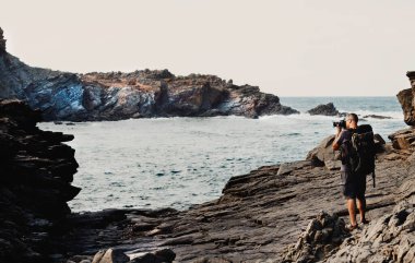 Kıyı manzarasını fotoğraflayan bir adam. Turizm kavramı, yaşam tarzı