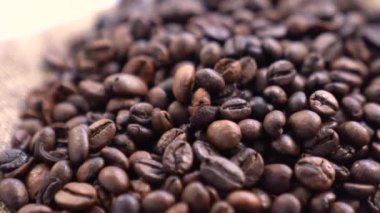 Sütlü kremayla karıştırılmış sıcak kahve. Kokulu kahve çekirdekleri kızartma tavasında kızartılır, duman kahve çekirdeklerinden gelir. Kahve tohumlarını kapat. Kokulu kahve çekirdekleri kavrulmuş. Kahve espresso yakın çekim buhar içeceği sıcak.