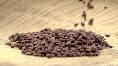 Sütlü kremayla karıştırılmış sıcak kahve. Kokulu kahve çekirdekleri kızartma tavasında kızartılır, duman kahve çekirdeklerinden gelir. Kahve tohumlarını kapat. Kokulu kahve çekirdekleri kavrulmuş. Kahve espresso yakın çekim buhar içeceği sıcak.