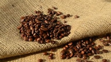 Sütlü kremayla karıştırılmış sıcak kahve. Kokulu kahve çekirdekleri kızartma tavasında kızartılır, duman kahve çekirdeklerinden gelir. Kahve tohumlarını kapat. Kokulu kahve çekirdekleri kavrulmuş. Kahve espresso yakın çekim buhar içeceği sıcak.