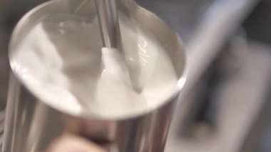 Sütlü kremayla karıştırılmış sıcak kahve. Kokulu kahve çekirdekleri kızartma tavasında kızartılır, duman kahve çekirdeklerinden gelir. Kahve tohumlarını kapat. Kokulu kahve çekirdekleri kavrulmuş. Kahve espresso yakın çekim buhar içeceği sıcak.