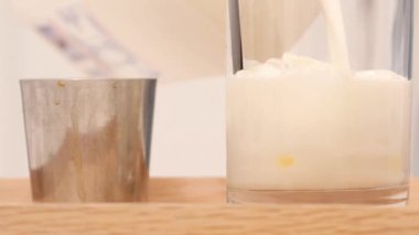 Sütlü kremayla karıştırılmış sıcak kahve. Kokulu kahve çekirdekleri kızartma tavasında kızartılır, duman kahve çekirdeklerinden gelir. Kahve tohumlarını kapat. Kokulu kahve çekirdekleri kavrulmuş. Kahve espresso yakın çekim buhar içeceği sıcak.