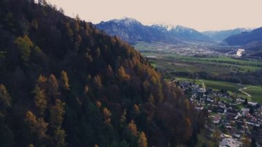 Yavaşça büyük ahşap bir iskelenin üzerinden göle doğru yürüyorlar ve göl suyunun üzerinde uçuyorlar. Bir dağ ormanı gölünde çam ağaçlarıyla birlikte turkuaz su. Mavi göl ve yeşil orman gölü havadan görünüyor. Sonbahar meşesi ormanında güzel sonbahar manzarası. 