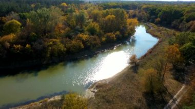 Yavaşça büyük ahşap bir iskelenin üzerinden göle doğru yürüyorlar ve göl suyunun üzerinde uçuyorlar. Bir dağ ormanı gölünde çam ağaçlarıyla birlikte turkuaz su. Mavi göl ve yeşil orman gölü havadan görünüyor. Sonbahar meşesi ormanında güzel sonbahar manzarası. 