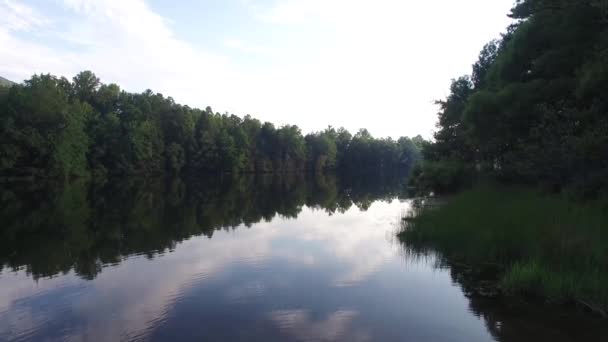 ゆっくりと湖に大きな木製の桟橋を歩いて 湖の水の上を飛んでいます 松の木と山の森の湖のターコイズブルーの水 青い湖と緑の森の湖の空中風景 — ストック動画