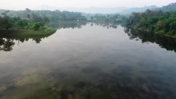 慢慢地走过一个巨大的木制防波堤 进入湖中 在湖水上空飞翔 山林湖中的绿松石水 有松树 蓝湖和绿林湖的空中景观 — 图库视频影像