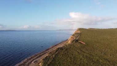 Hava Sahil Dalgaları - Okyanus mavi dalgalarının yukarıdan görünüşü bir kumsalda kırılıyor. Gök suyu, kumlu tropik plaj. Atlantik Okyanusu plaj günbatımı. Dalgalar mavi bir okyanusta kayalarda kırılır. Sahildeki su dalgaları.