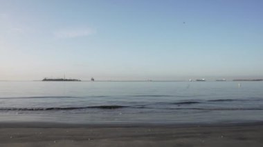 Hava Sahil Dalgaları - Okyanus mavi dalgalarının yukarıdan görünüşü bir kumsalda kırılıyor. Gök suyu, kumlu tropik plaj. Atlantik Okyanusu plaj günbatımı. Dalgalar mavi bir okyanusta kayalarda kırılır. Sahildeki su dalgaları.