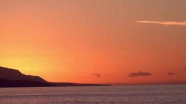 Su dalgalarıyla güzel tropikal turist plajı, okyanus dalgaları manzaraları ve Atlantik Okyanusu sahil günbatımları. Güneş dönen bulutlarda sürükleniyor. Fantastik doğal günbatımı, 124. Bulanık sesli ses görüntüleri..