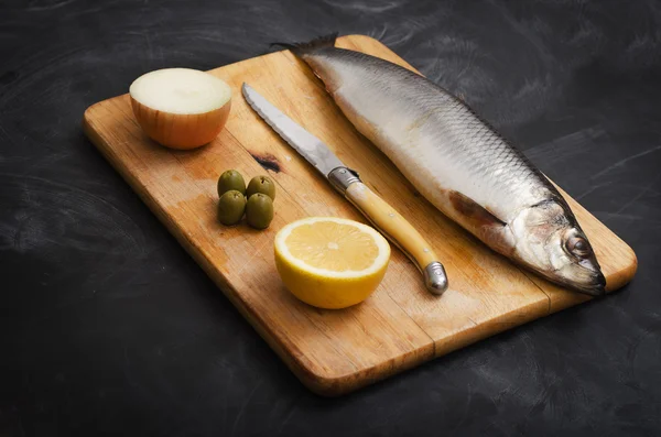 Limon ve soğan bir kesme tahtası üzerinde ringa balığı